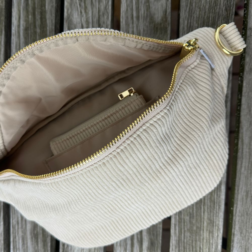 Stylische Cord-Bauchtasche geöffnet mit Sicht auf Einsteckfach mit Cord-Etui.
