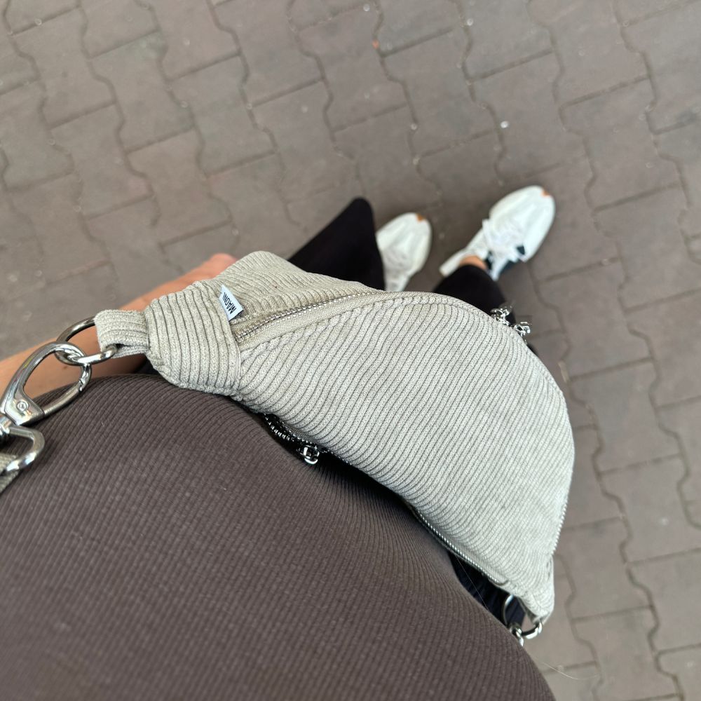 Grüne Cord Bauchtasche Crossbody getragen. Frau macht Selfie, sichtbar aus der Draufsicht.