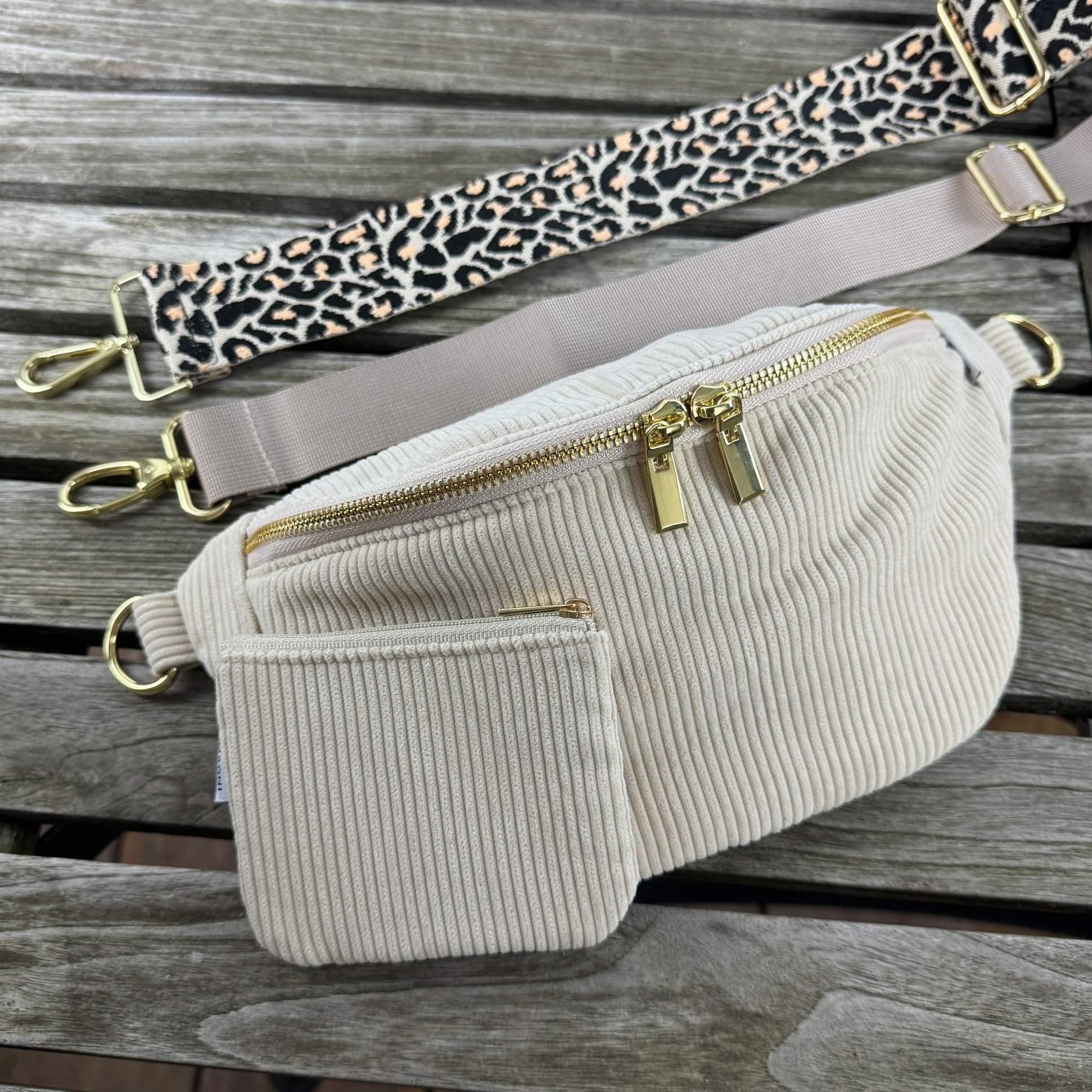 Praktische Bauchtasche aus Cord mit zwei verstellbaren und auswechselbaren Gurten und gleichfarbigen Cord Etui. Ein Gurt ist einfarbig, der andere im modernen Leo-Look.