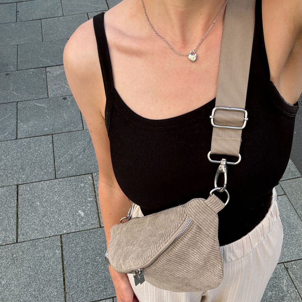 Grüne Cord Bauchtasche getragen von Frau mit sommerlichem Outfit.