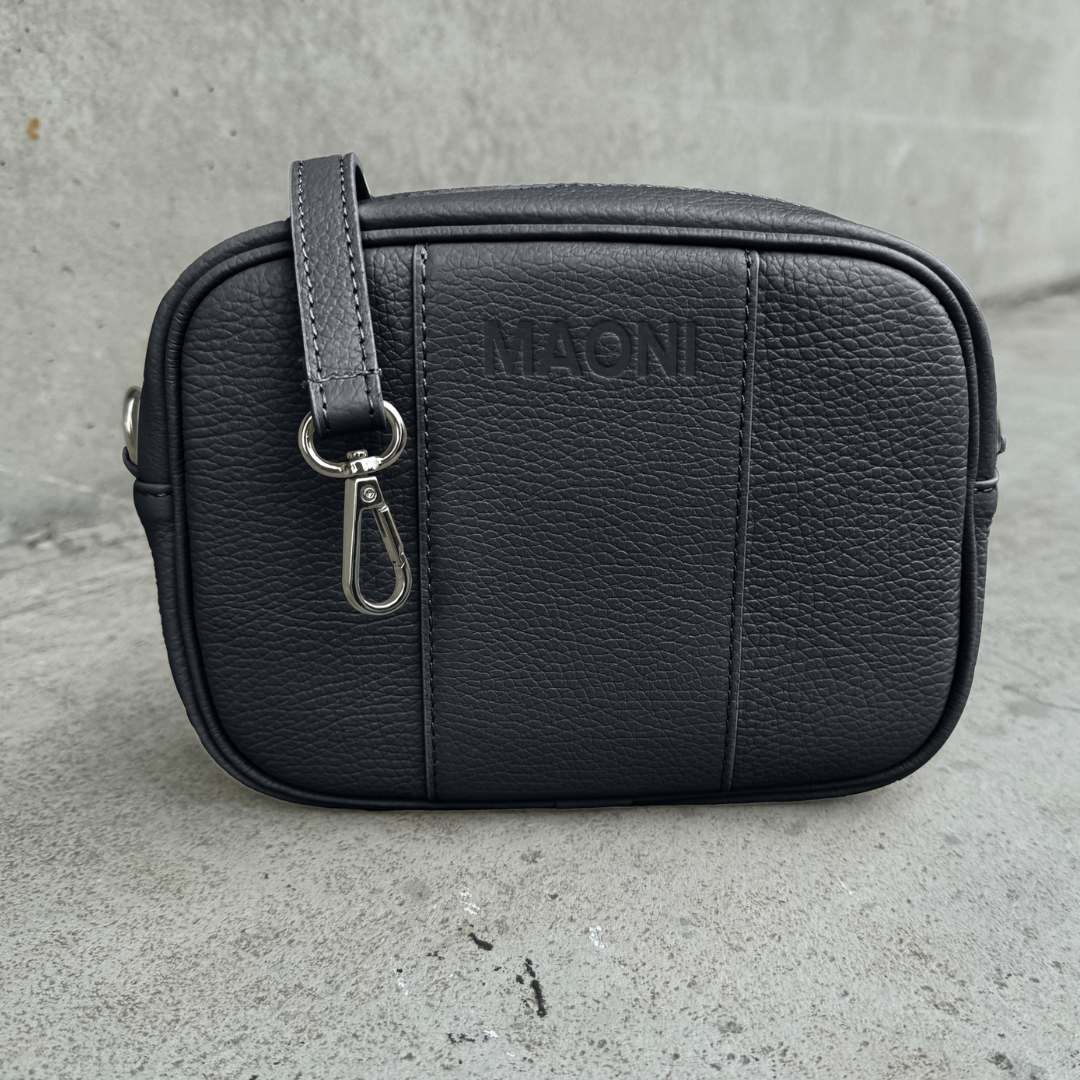Crossbody-Tasche MAONI – Farbe Schwarz, mit silberfarbenem Verschluss und austauschbaren Ledergurt.
