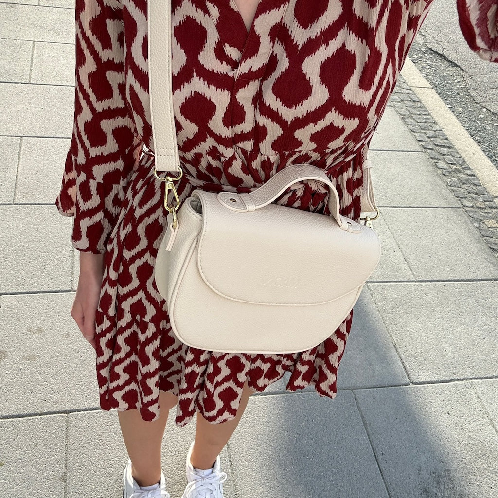 Frau trägt die beige Halfmoon-Tasche am langen Gurt Crossbody – aus der Selfieperspektive aufgenommen