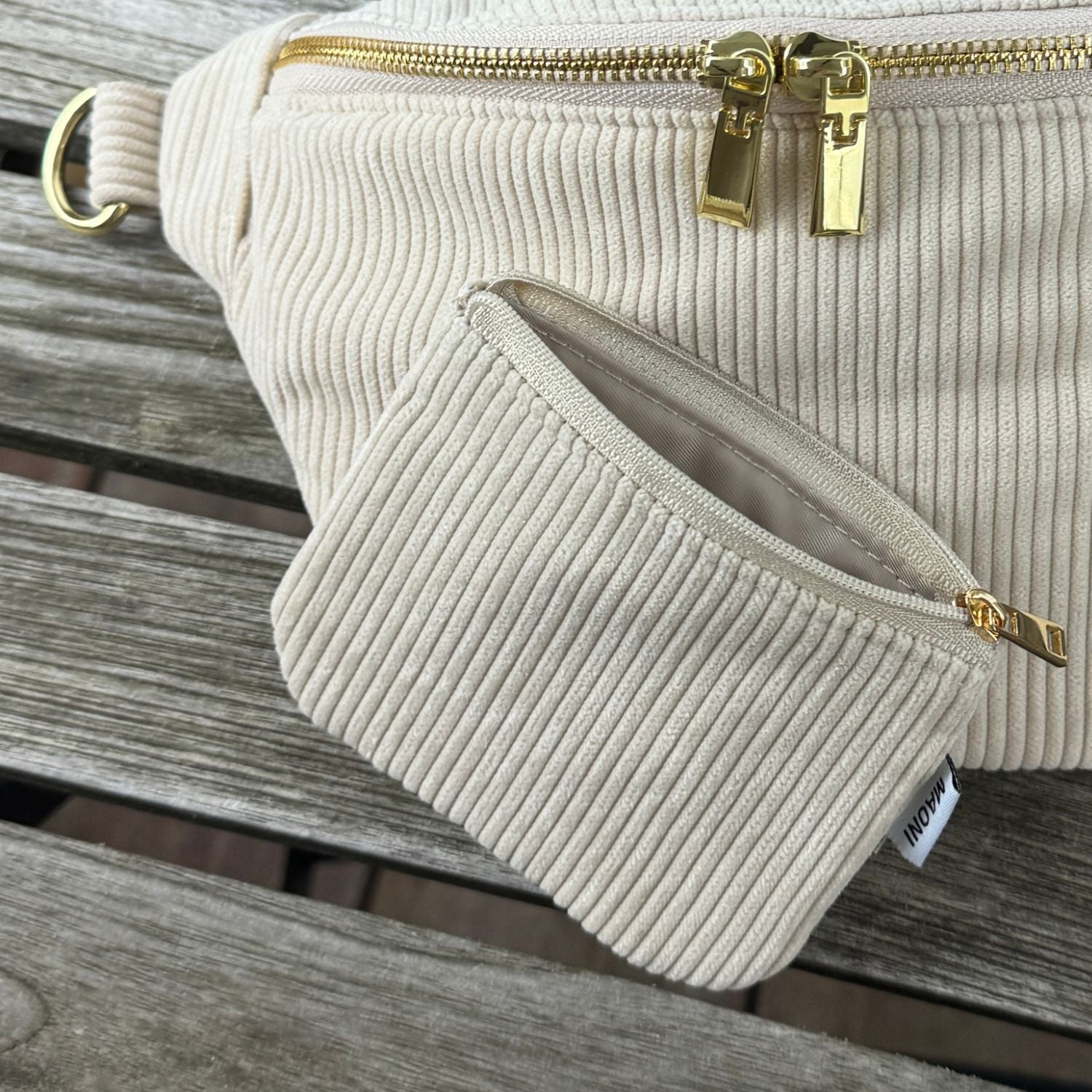 Cord Etui liegt offen und ist an Cord Bauchtasche angelehnt.