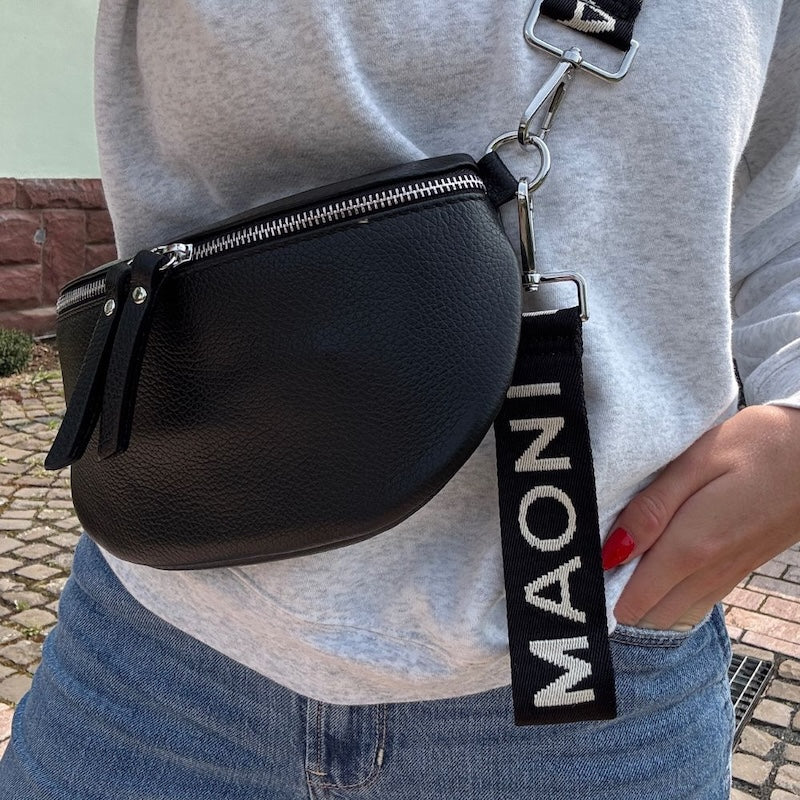 MAONI-Schlüsselanhänger an schwarze Lederbauchtasche gehängt