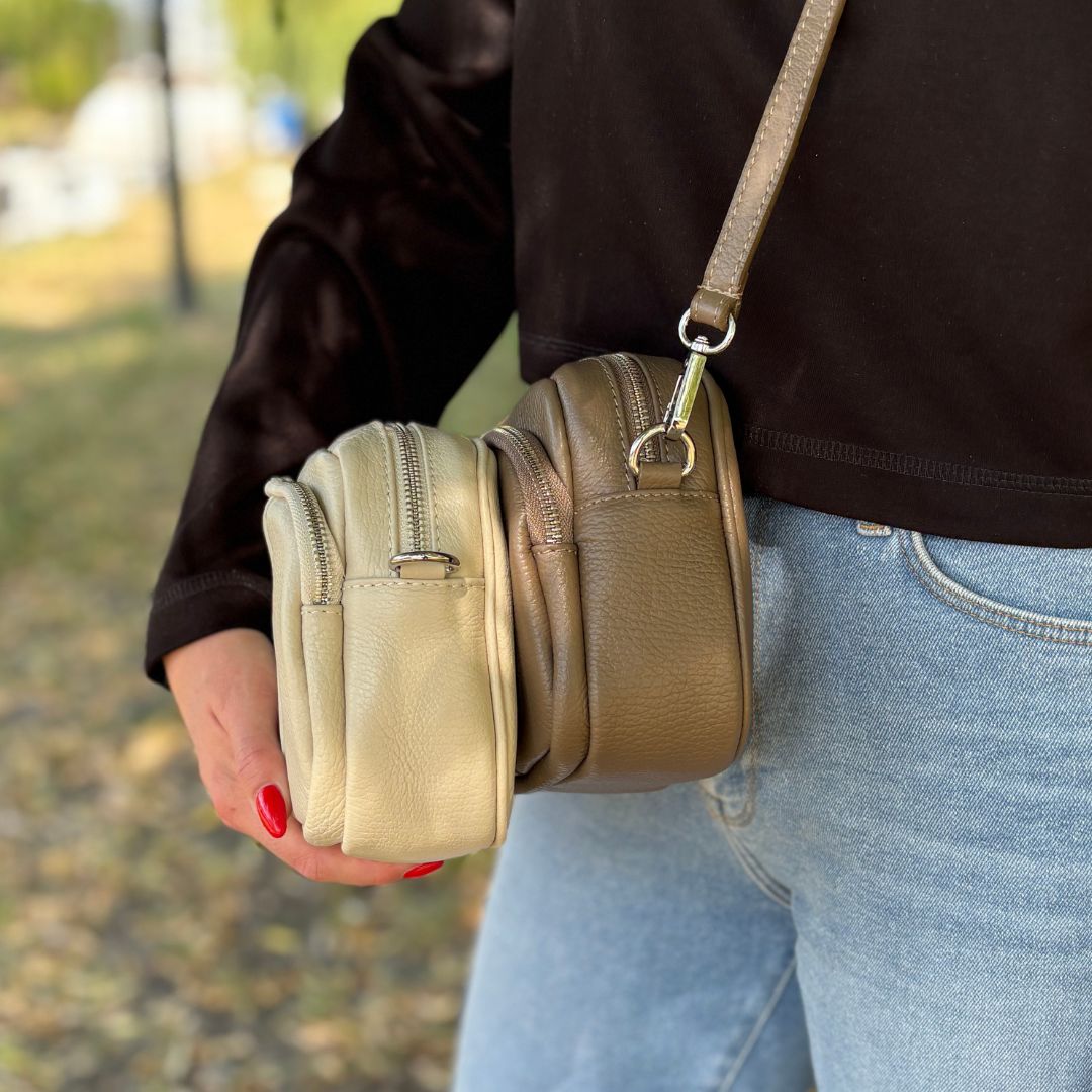 Seitenansicht der Crossbody-Tasche in Beige und Dunkeltaupe mit sichtbarem Frontfach für Handy