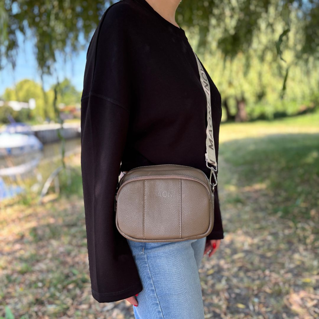 Lässiger Outdoor-Look mit schwarzem Pullover, Jeans und Crossbody-Tasche – perfekt für den Alltag in der Natur.
