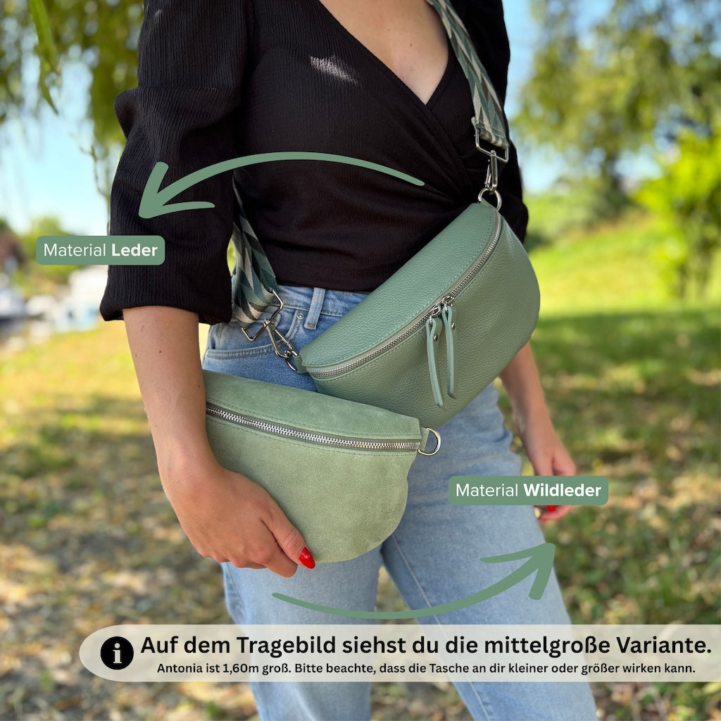 Vergleich: Mittelgroße grüne Bauchtasche aus Glattleder crossbody getragen, Wildleder-Variante in der Hand gehalten – beide Modelle in Grün von Frau präsentiert