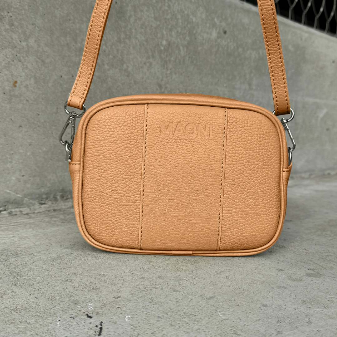 Elegante MAONI Handtasche in Cognac mit schlichtem Ledergurt und edlem silbernem Verschluss.