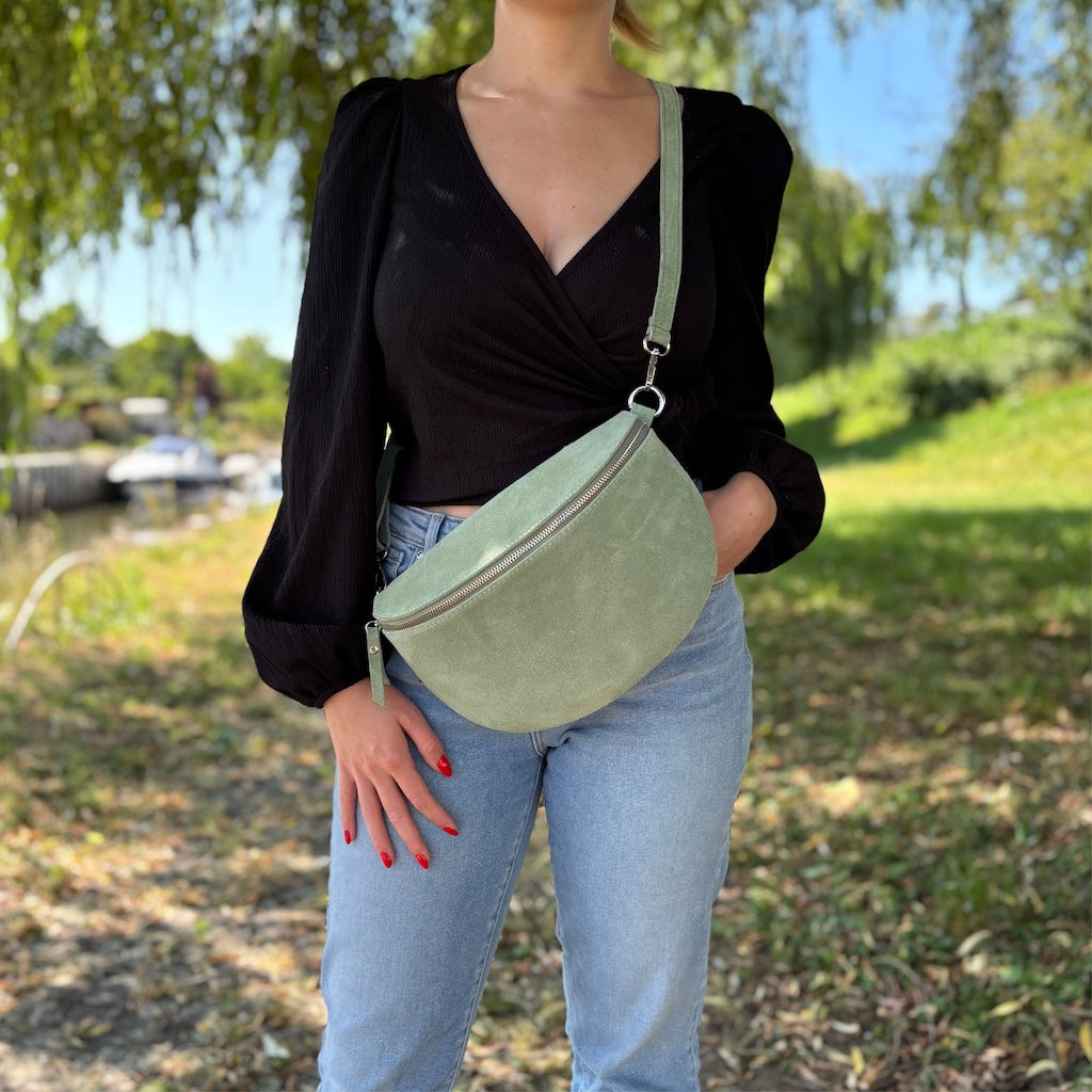 Große grüne Bauchtasche aus Wildleder mit softer Struktur – lässig getragen in der Natur als stilvoller Alltagsbegleiter
