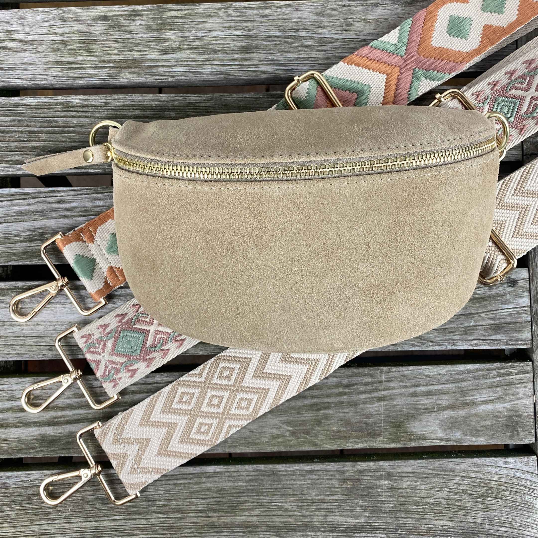 Edle taupefarbene Wildleder-Bauchtasche mit drei gemusterten Taschengurten und goldfarbenem Verschluss – ein modisches Accessoire für jeden Tag