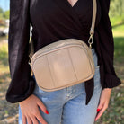 Damen-Crossbody-Tasche in sand-taupefarbener Nuance – lässig getragen als stilvolles Alltagsaccessoire